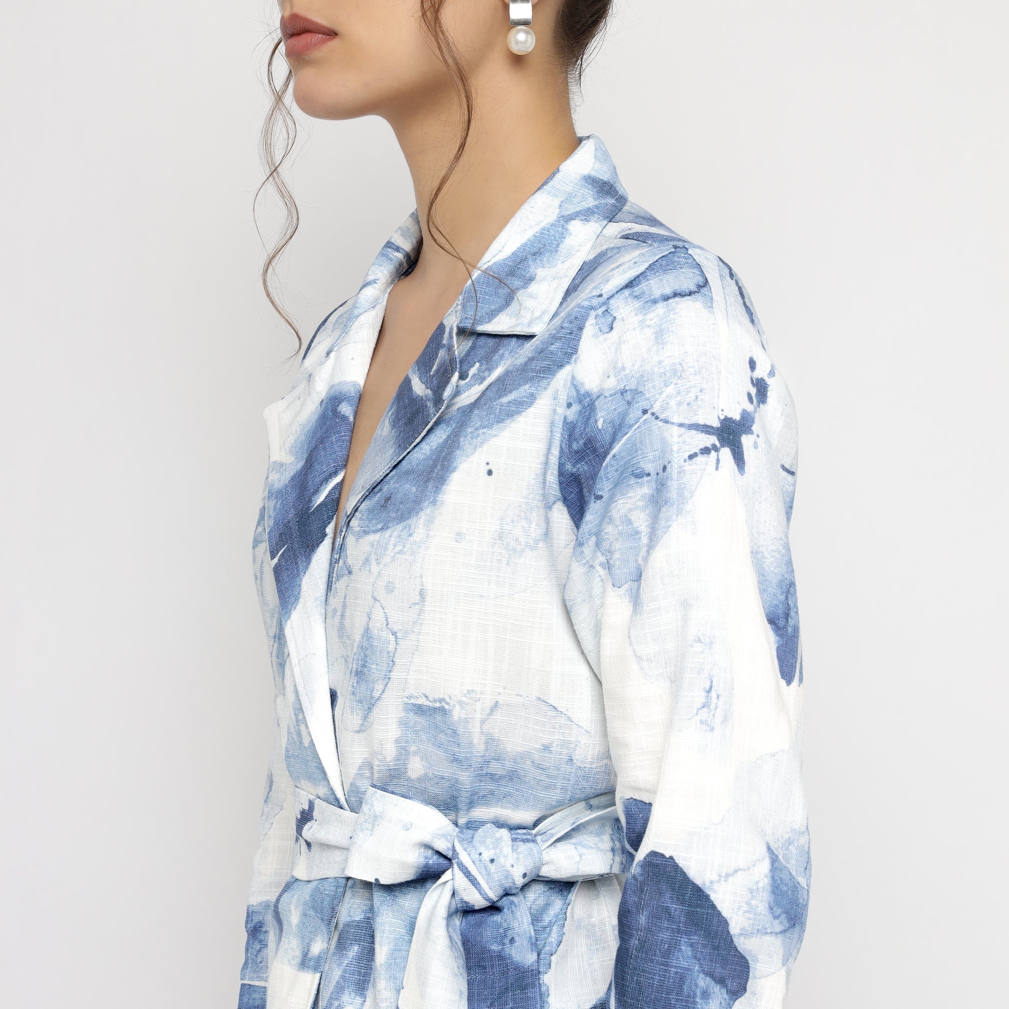 Side profile of woman wearing Blue & White Watercolor Printed Blazer highlighting collar, sleeve, and waist belt details.